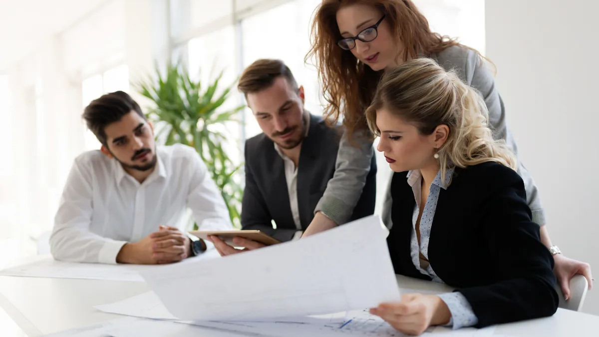 A business team discussing plans and reviewing documents around a table