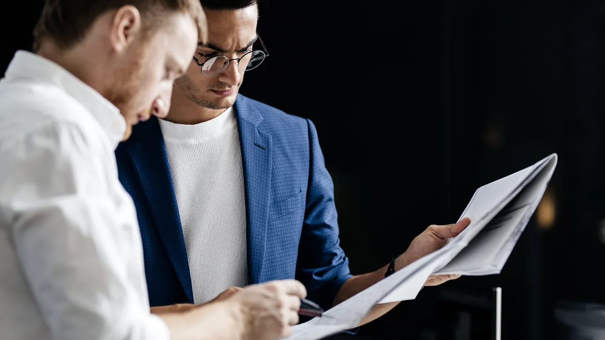 Two colleagues examining printed financial information